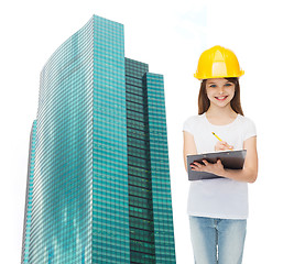 Image showing smiling little girl in hardhat with clipboard