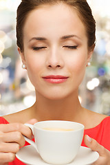 Image showing smiling woman in red dress with cup of coffee