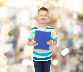 Image showing smiling little student boy with blue book