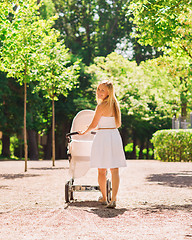 Image showing happy mother with stroller in park