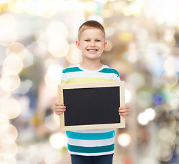 Image showing smiling little boy holding blank black chalkboard