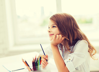 Image showing little student girl drawing and dreaming at school