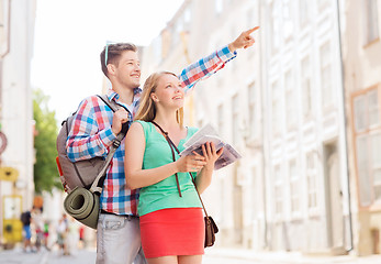 Image showing smiling couple with city guide and backpack