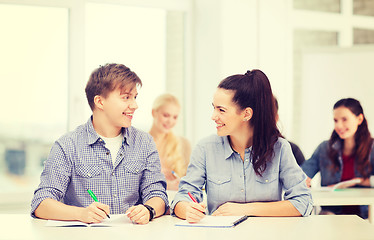 Image showing two teenagers with notebooks at school