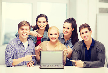 Image showing smiling students pointing to blank lapotop screen