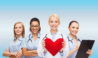 Image showing smiling female doctor and nurses with red heart