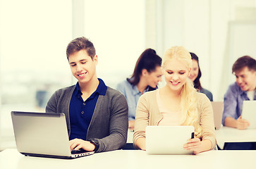 Image showing two smiling students with laptop and tablet pc