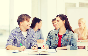 Image showing two teenagers with notebooks and book at school