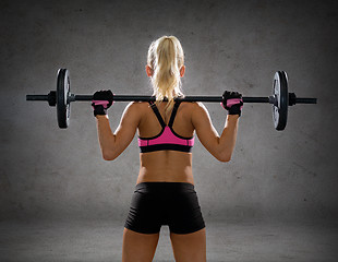 Image showing sporty woman exercising with barbell from back