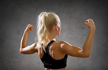 Image showing sporty woman from the back flexing her biceps