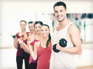 Image showing group of smiling people with dumbbells in the gym