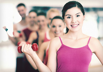 Image showing group of smiling people with dumbbells in the gym