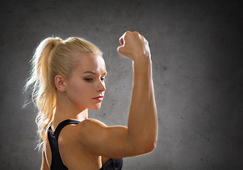 Image showing sporty woman from the back flexing her biceps