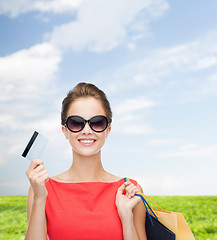 Image showing smiling woman with shopping bags and plastic card