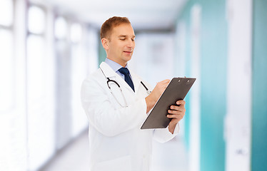 Image showing smiling male doctor with clipboard and stethoscope