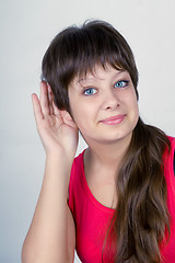 Image showing A smiling young girl listening attentively