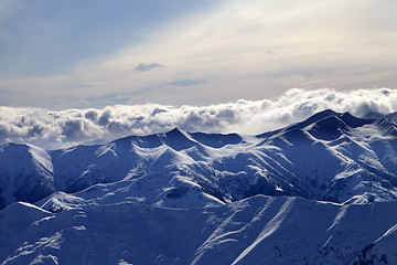 Image showing Evening snowy mountains and sunlight clouds