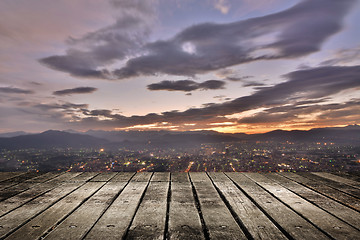 Image showing City sunset with wooden ground