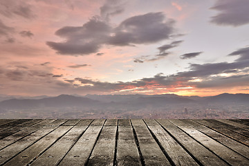Image showing City sunset with wooden ground