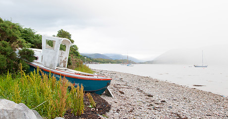 Image showing Small shipwreck at a loch with stone beach