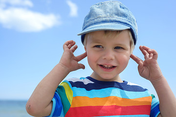 Image showing Small boy holds his hands over ears not to hear