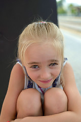 Image showing Little girl hugging her knees