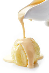 Image showing vanilla sauce pouring on baked apple