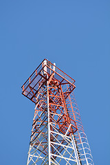 Image showing Telecommunication mast with microwave link and TV transmitter antennas on blue sky.