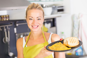 Image showing Young Mother Cooking at Home.