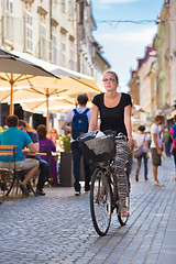 Image showing Woman riding bicycle in city center.