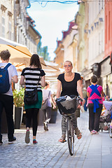 Image showing Woman riding bicycle in city center.