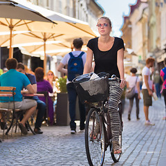 Image showing Woman riding bicycle in city center.