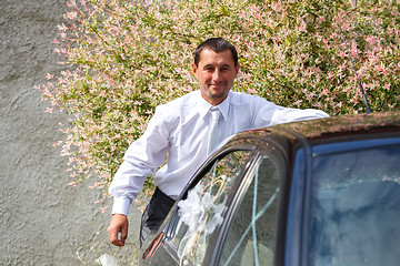 Image showing groom preparing and decoration car in wedding day