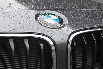 Image showing BMW logo on wet surface of car hood