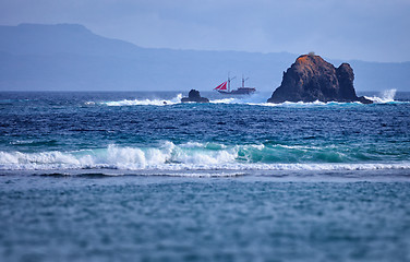 Image showing Old two-masted schooner near the rocks in the sea. Indonesia, Ba