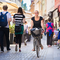 Image showing Woman riding bicycle in city center.