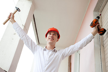 Image showing engineer with a tools in raised hands