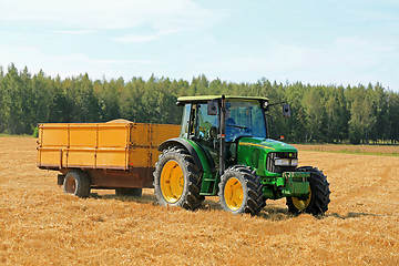 Image showing Farmer Driving John Deere 5820 Tractor and Trailer 