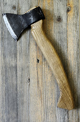 Image showing ax with oak handle on a wooden background, vertical