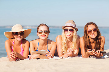 Image showing group of smiling young women with tablets on beach