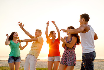 Image showing smiling friends dancing on summer beach