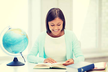 Image showing teacher with globe and book at school