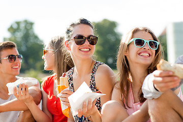 Image showing group of smiling friends sitting on city square