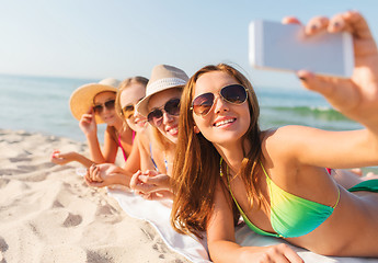 Image showing group of smiling women with smartphone on beach