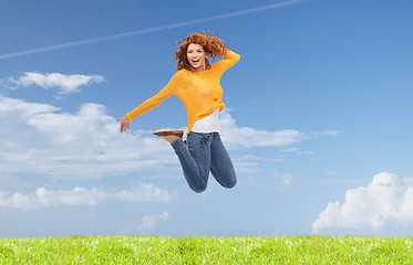 Image showing smiling young woman jumping in air