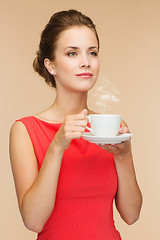 Image showing smiling woman in red dress with cup of coffee