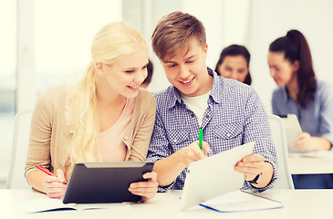 Image showing two smiling students with tablet pc and notebooks