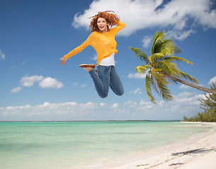 Image showing smiling young woman jumping in air