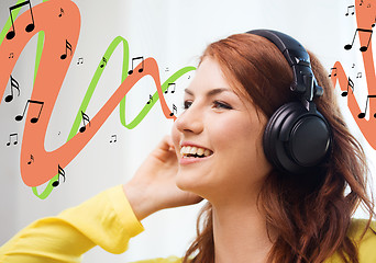 Image showing smiling young girl in headphones at home