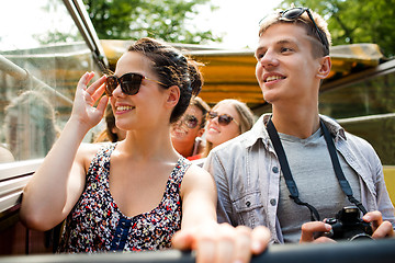 Image showing smiling couple with camera traveling by tour bus